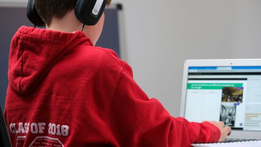 boy in red hoodie wearing black headphones