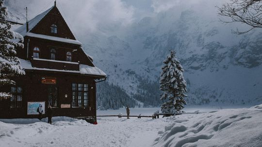 a cabin in the mountains covered in snow