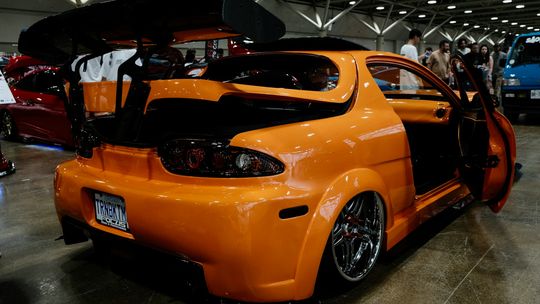 An orange car parked inside of a garage