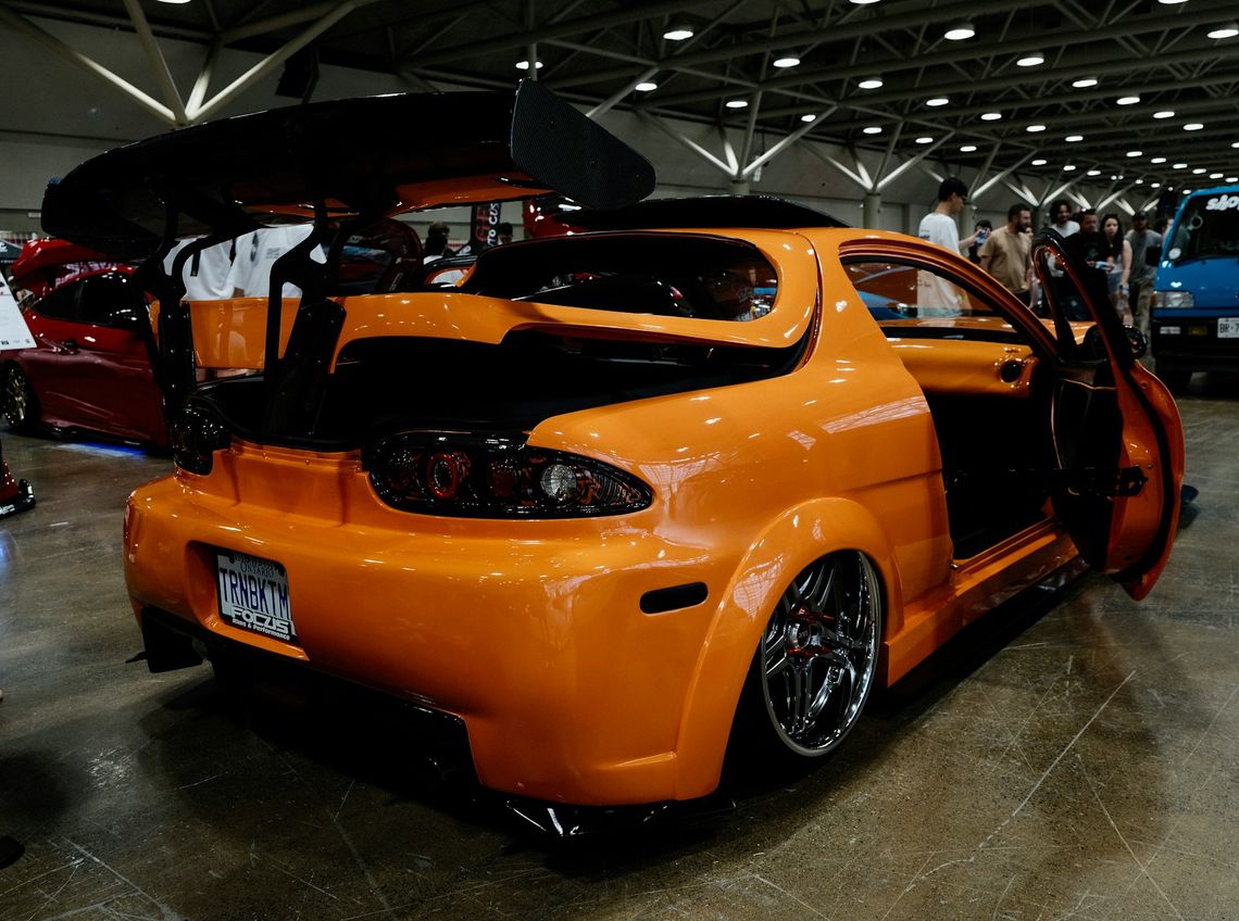 An orange car parked inside of a garage